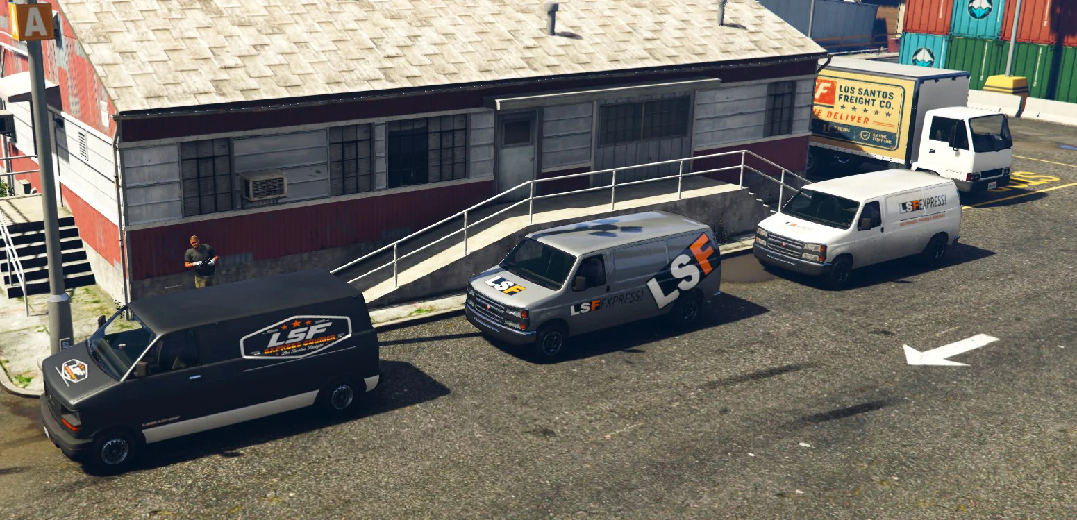 Four LS Freight delivery vehicles parked outside a Los Santos depot.